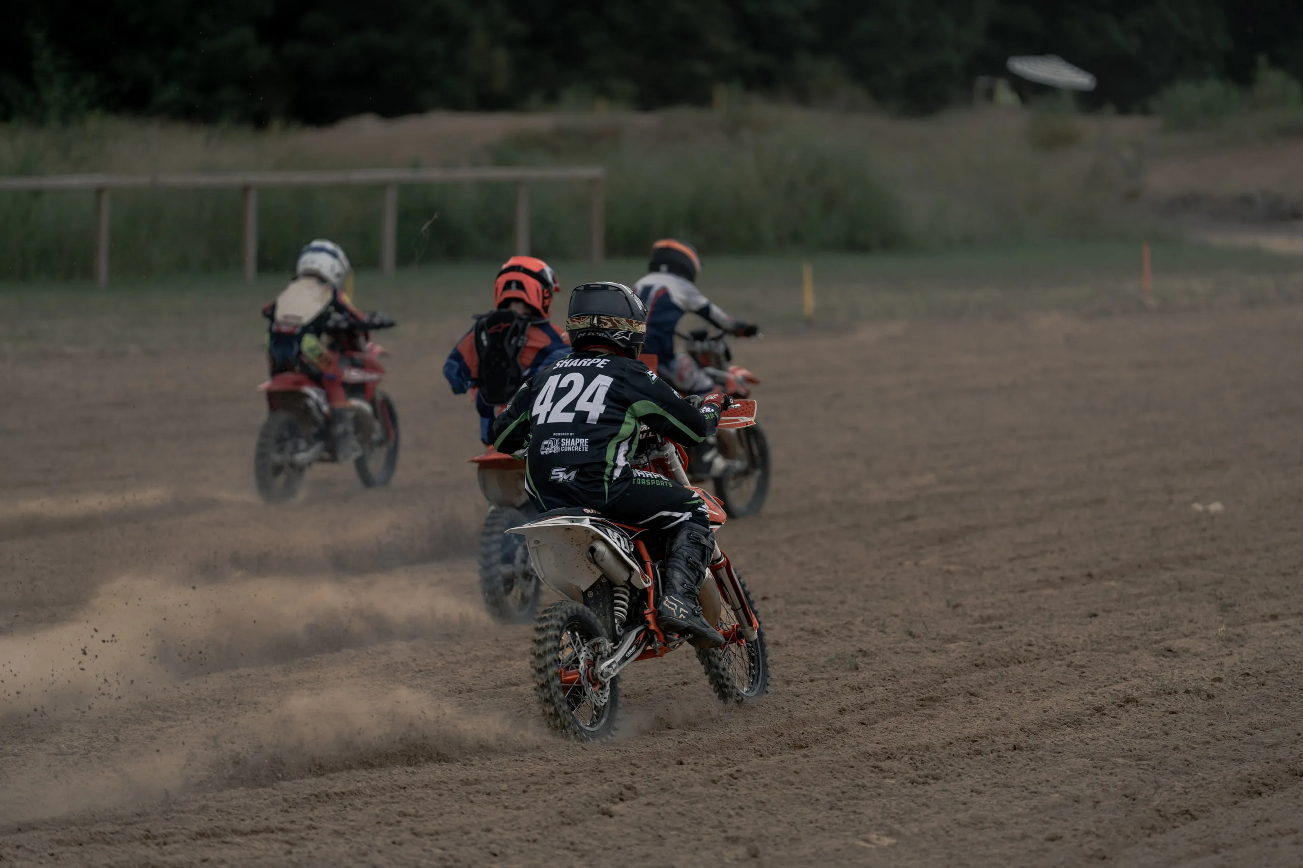 A pack of young riders pulls away down a straight, the rider in the middle carrying number 424